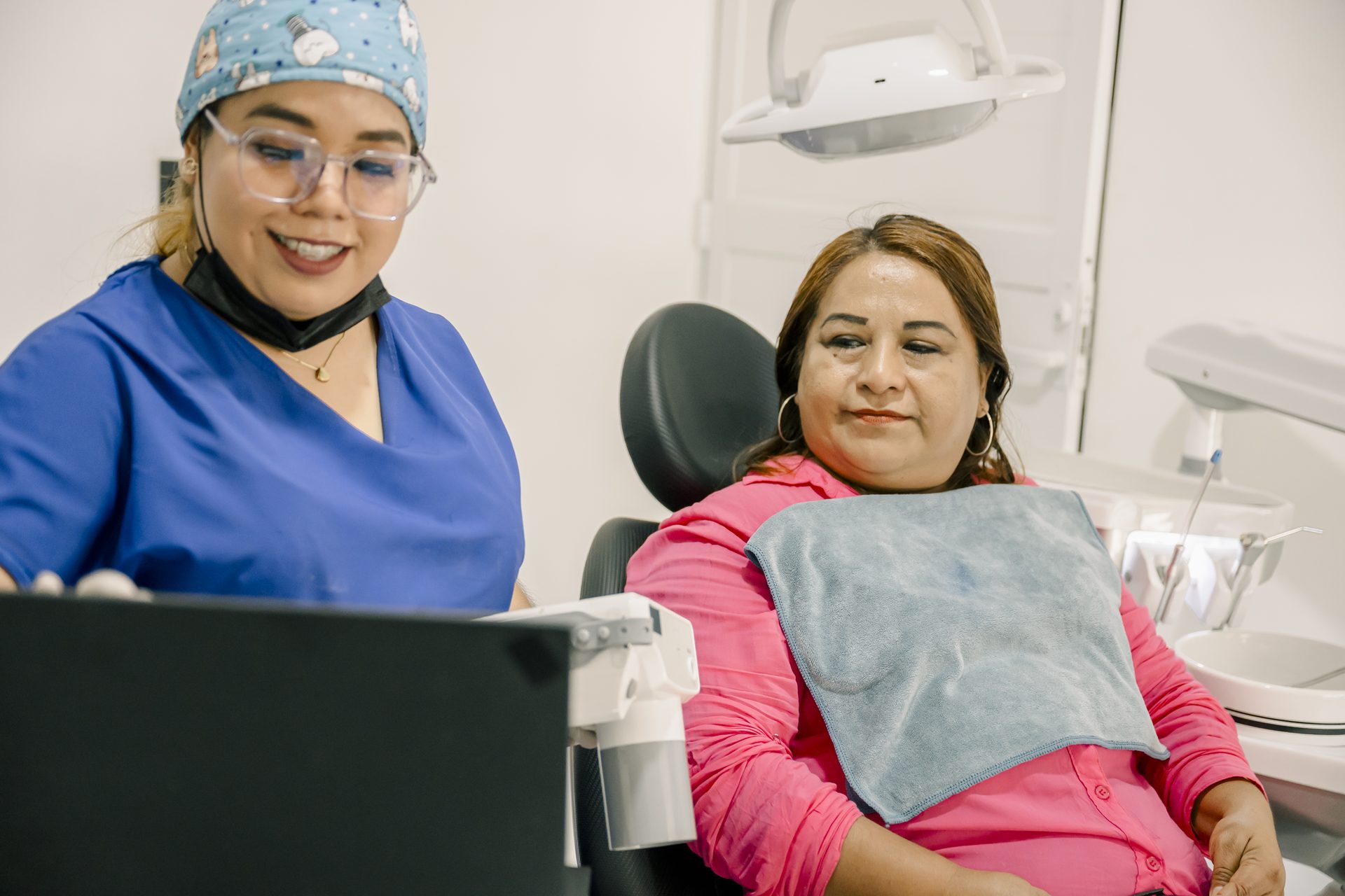Female dentist showing information on a laptop to a patient