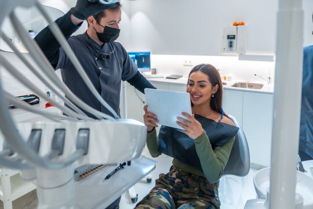 Dentist showing results on tablet to patient in mo, Tijuana