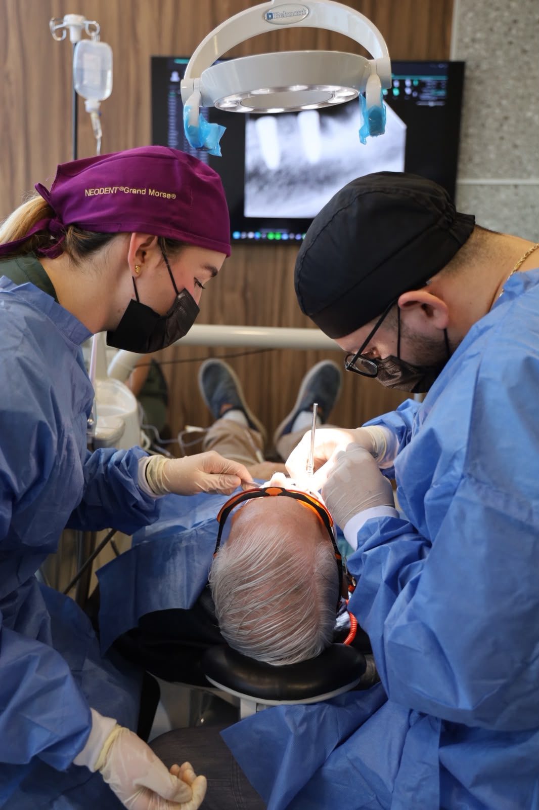 Surgical team operating with radiographs on screen at Makeover Dental Studio in Tijuana
