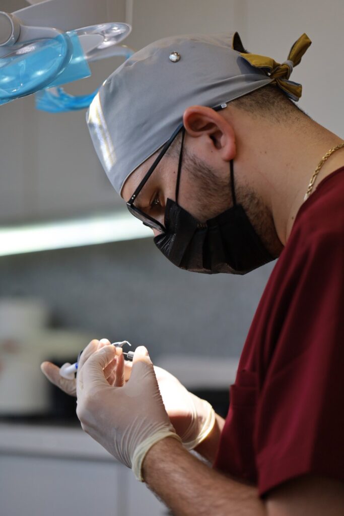 Surgeon in a cap and loupes handling instruments