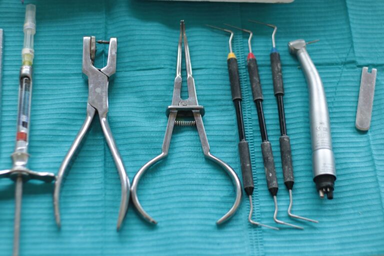 Dental instruments, syringe and forceps on a teal cloth