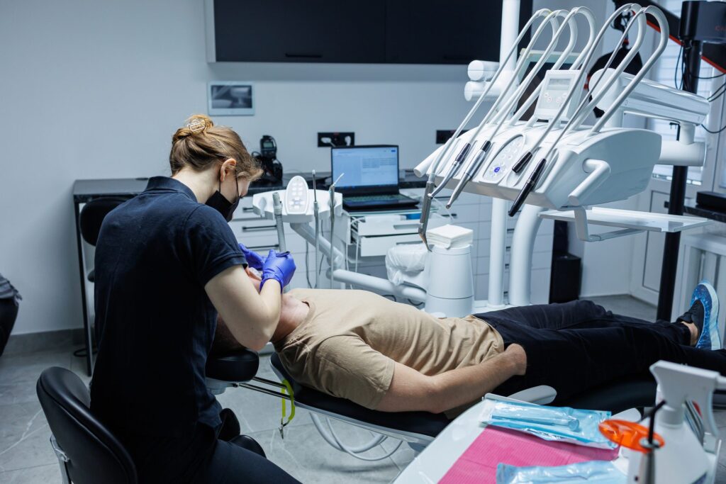 Dimly lit dental office with a patient in the chair